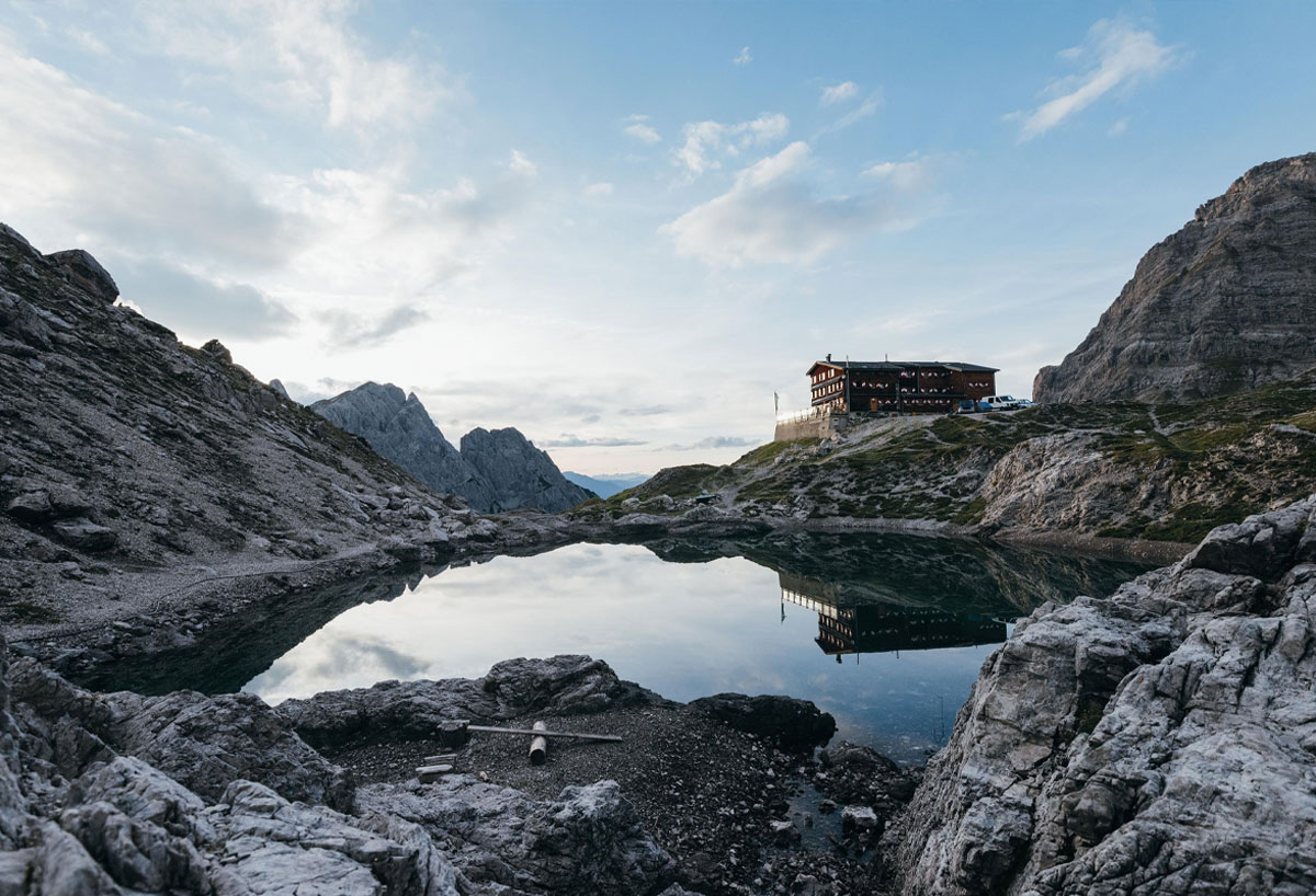 Bergalm an einem kleinen See im Morgenlicht